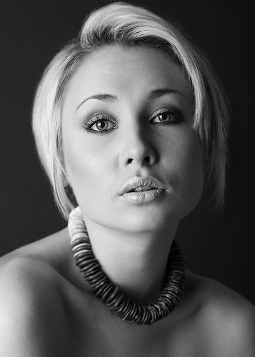 Black and white studio portrait of a woman wearing a statement necklace